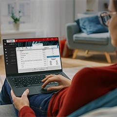 a woman with her laptop on the sofa, on the screen is the 24You internetbanking
