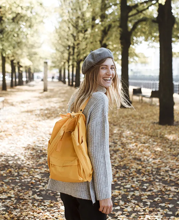 Eine junge Frau in einer Allee unterwegs