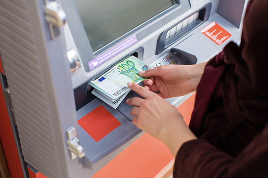 Person steckt Geld in den Bargeldmanager